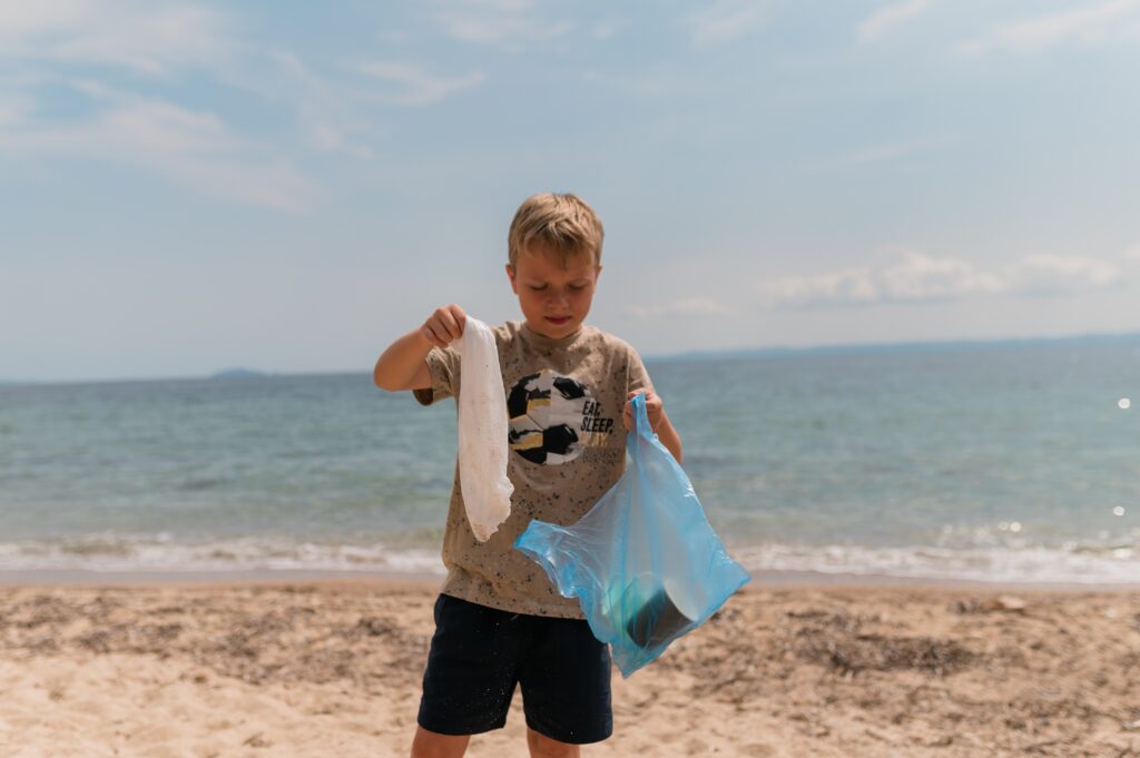 young-boy-volunteer-cleaning-up-litter-on-sunny-be-2023-11-27-04-50-23-utc